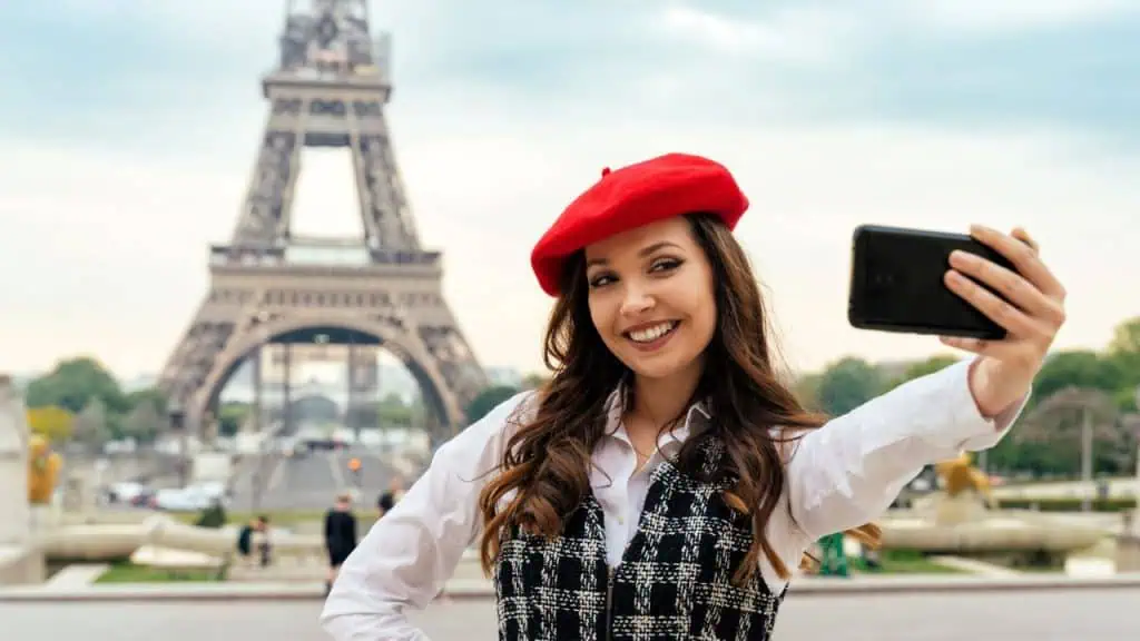 Woman making selfie in front of Eifel Tower in Paris, France