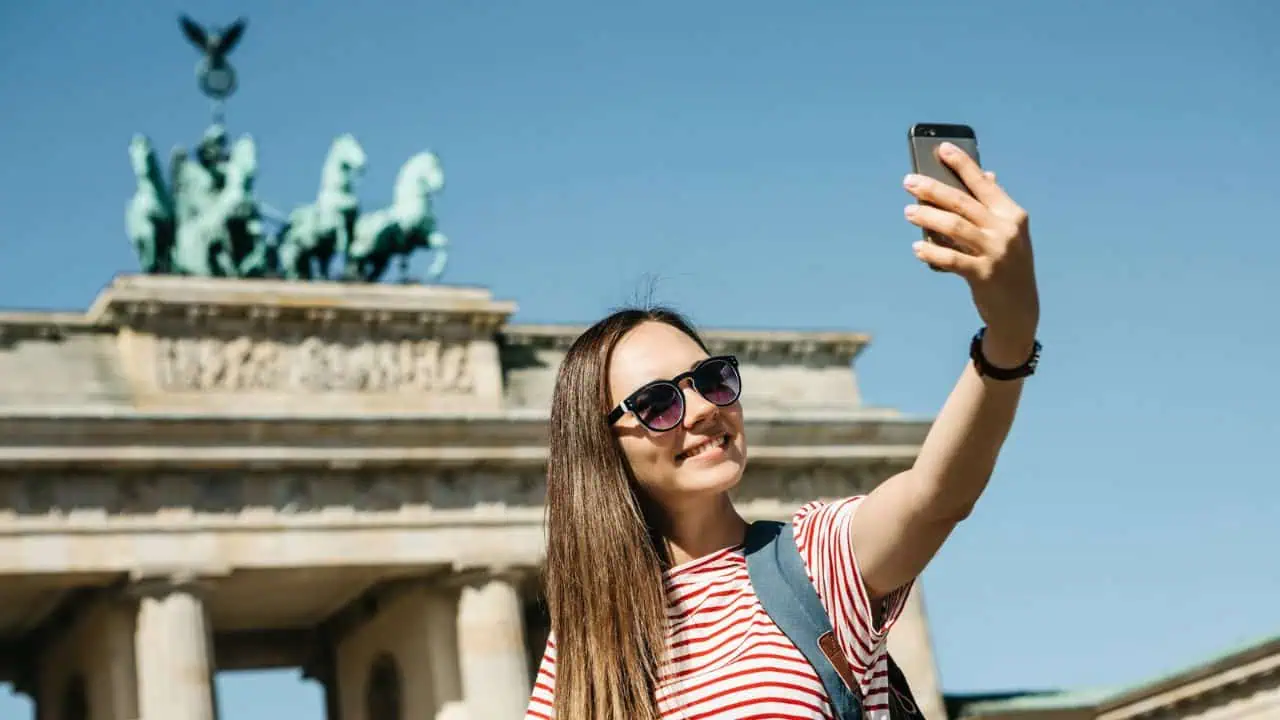 Woman making selfie in front of Branderburger Tor, Berlin, Germany