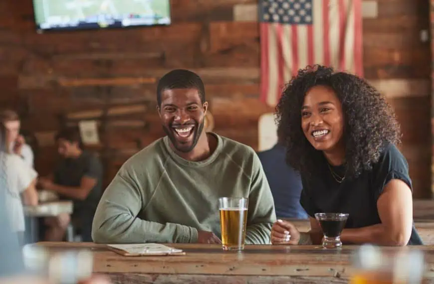 Young couple meeting in sports bar drinking